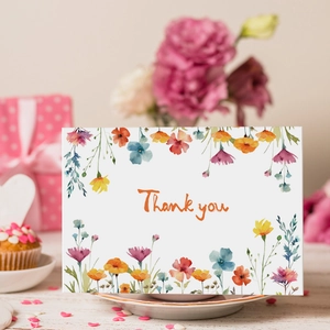 Détail d'une carte de remerciement aquarelle fleurs des champs sur un plateau en céramique