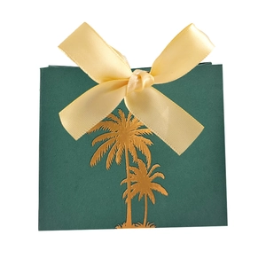 Detail of green Saudi National Day candy box with gold palm tree and yellow ribbon