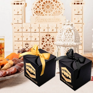 Elegant black Umrah Mubarak gift boxes with gold Kaaba motifs and silk ribbons