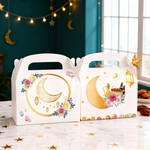 White Eid gift paper box with golden crescent moon and floral patterns on marble table