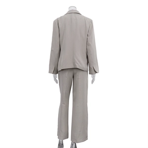 Rear view of beige three-piece business suit featuring a blazer and wide leg trousers