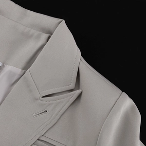 Close-up of the elegant notched lapel and fine stitching on the grey formal suit jacket