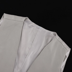 Close-up of light grey vest V-neckline with size S label and smooth inner lining
