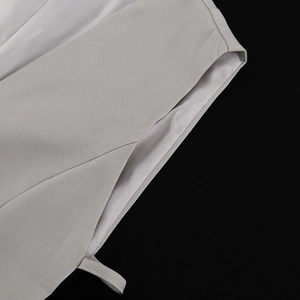 Detailed close-up of light gray blazer stitching with white silky lining and fabric texture