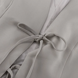 Close-up of the lace-up waist detail and premium woven fabric on a grey blazer set