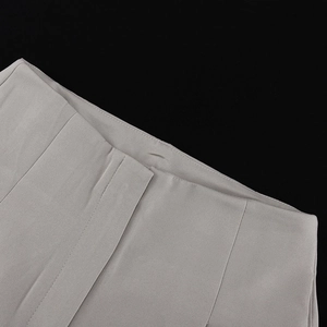 Detailed close-up of fine stitching and fabric texture on grey wide-leg trousers