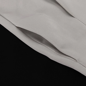 Detail of invisible side seam pocket on gray woven wide-leg pants and blazer suit