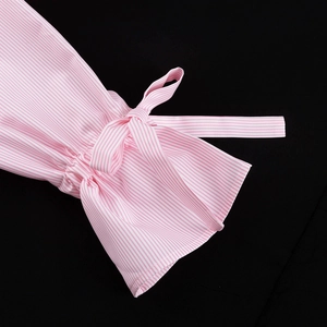 Detail eines rosa gestreiften Hemdärmels mit ausgestelltem Bund und Schleife