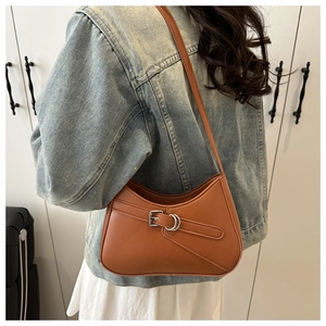 Close-up of retro brown half-moon baguette bag with adjustable silver buckle strap