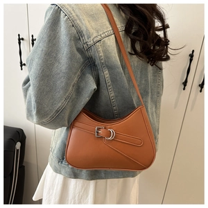 Caramel baguette bag shown over shoulder with silver buckle detail on smooth leather