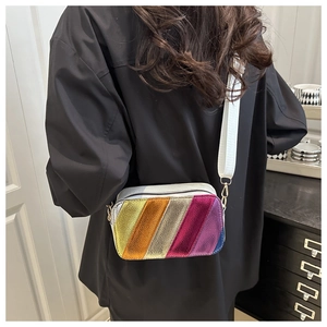 Close-up of rainbow striped metallic leather camera bag with a wide fabric shoulder strap