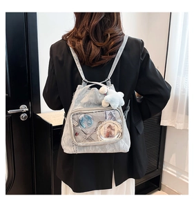 Detail of silver ita bag with transparent PVC layer and white plush star accessory