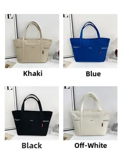 Detail view of large canvas tote bag showing khaki, blue, black, and off-white color options