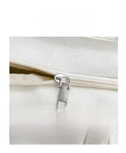 Detailed view of the smooth silver zipper closure on a durable beige canvas tote bag