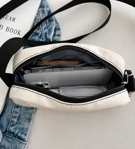 Top view of white travel makeup bag showing spacious interior with zipper and black strap