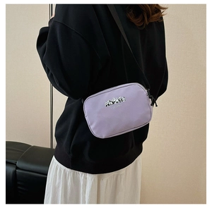 Detail of lavender canvas crossbody bag with panda prints worn by a model