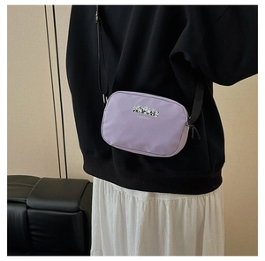 Detail of purple panda makeup bag with adjustable shoulder strap worn as crossbody