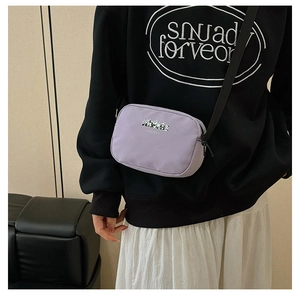 Detail of purple square travel pouch featuring a panda print and adjustable black strap