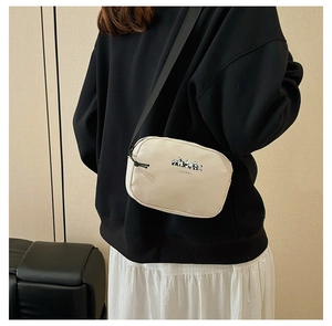 Close-up of cream crossbody travel bag with panda print and adjustable black strap