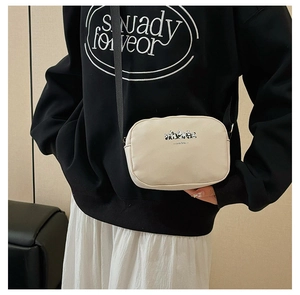 Detailed view of cream canvas travel cosmetic bag featuring cute panda prints and strap