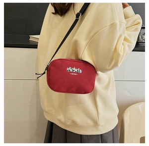 Compact red canvas crossbody travel bag with panda print and adjustable strap detail