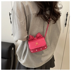 Détail du mini sac bandoulière rose fuchsia avec grand nœud et motif à pois blancs