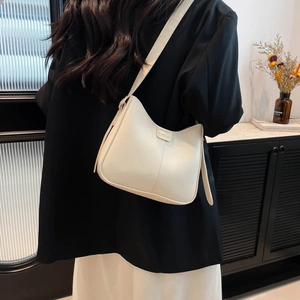 Sac hobo chic en similicuir blanc crème avec étiquette mode porté par un mannequin