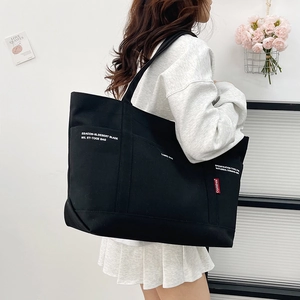 Fashionable black canvas tote bag with industrial white print and shoulder strap