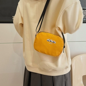 Yellow panda canvas crossbody bag with adjustable strap worn by a model in a casual outfit