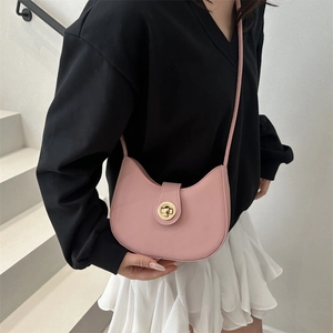 Pink minimalist half-moon crossbody bag with gold metal buckle shown on a model
