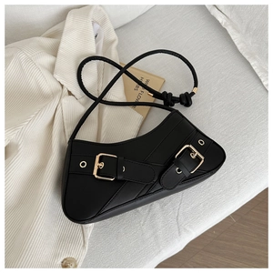 Detail of black crescent shoulder bag with diagonal stitching and gold metallic buckles