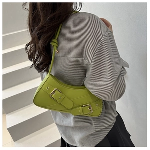 Close-up of avocado green Y2K crescent bag with buckle straps and knotted shoulder strap