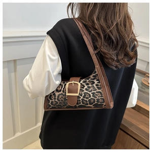 Dettaglio borsa sottospalla leopardata con grande fibbia dorata e cinturino marrone