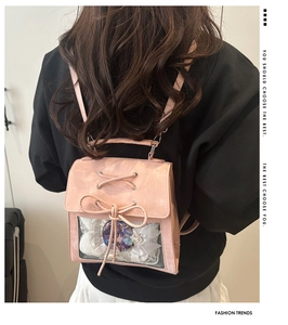 Detail of pink ita bag featuring large transparent window and cute ribbon bow lace