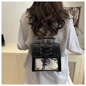 Detail of black ita bag with transparent window showing anime badges and bow decoration