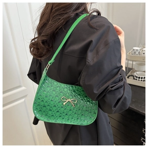 Détail du sac hobo vert vif avec texture bulles 3D et décoration nœud doré élégant
