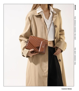 Close-up of brown V-quilted chain shoulder bag with a matching mini pouch on a model