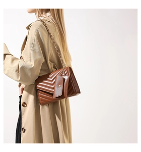 Detail of dark brown V-quilted crossbody bag with gold chain strap and coin pouch