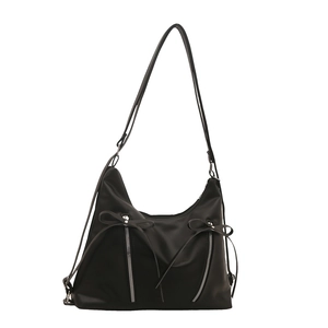 Elegant black crescent shoulder bag with ribbon bows and waterproof nylon finish