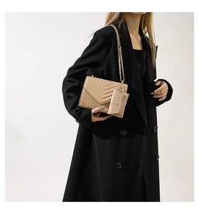 Quilted chain shoulder bag in beige with matching small coin purse on a black coat