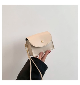 Detail view of a beige quilted mini pouch with a gold button closure and wristlet strap