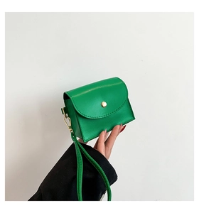 Macro shot of green mini leather pouch with gold clasp and matching wrist strap