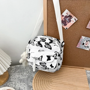Borsa a tracolla in tela bianca con stampe di farfalle e portachiavi a forma di orsetto