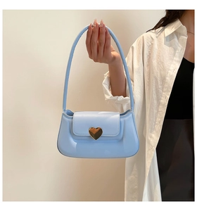 Detail of light blue PU leather bag featuring a large gold heart-shaped metal buckle