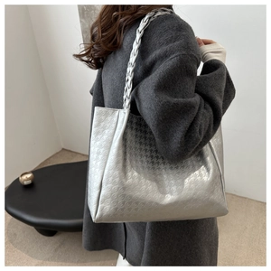 Détail du sac cabas argenté avec motif pied-de-poule et poignées tressées à l'épaule