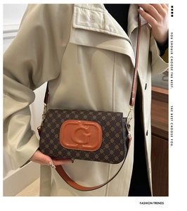 Detail of retro monogram flap bag with orange G-logo and adjustable leather strap