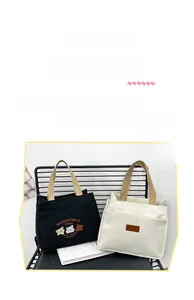 Detail of small canvas lunch bags in black and white with contrasting brown handles