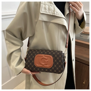 Detail of vintage retro shoulder bag featuring brown monogram pattern and orange G logo
