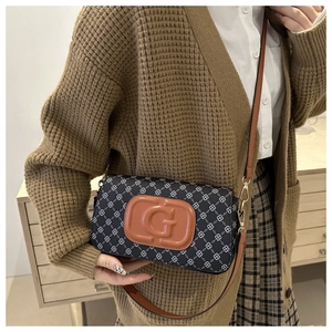Detail of vintage patterned crossbody bag with leather G logo patch and gold hardware