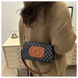 Detail of retro monogram patterned shoulder bag with brown leather G patch and strap